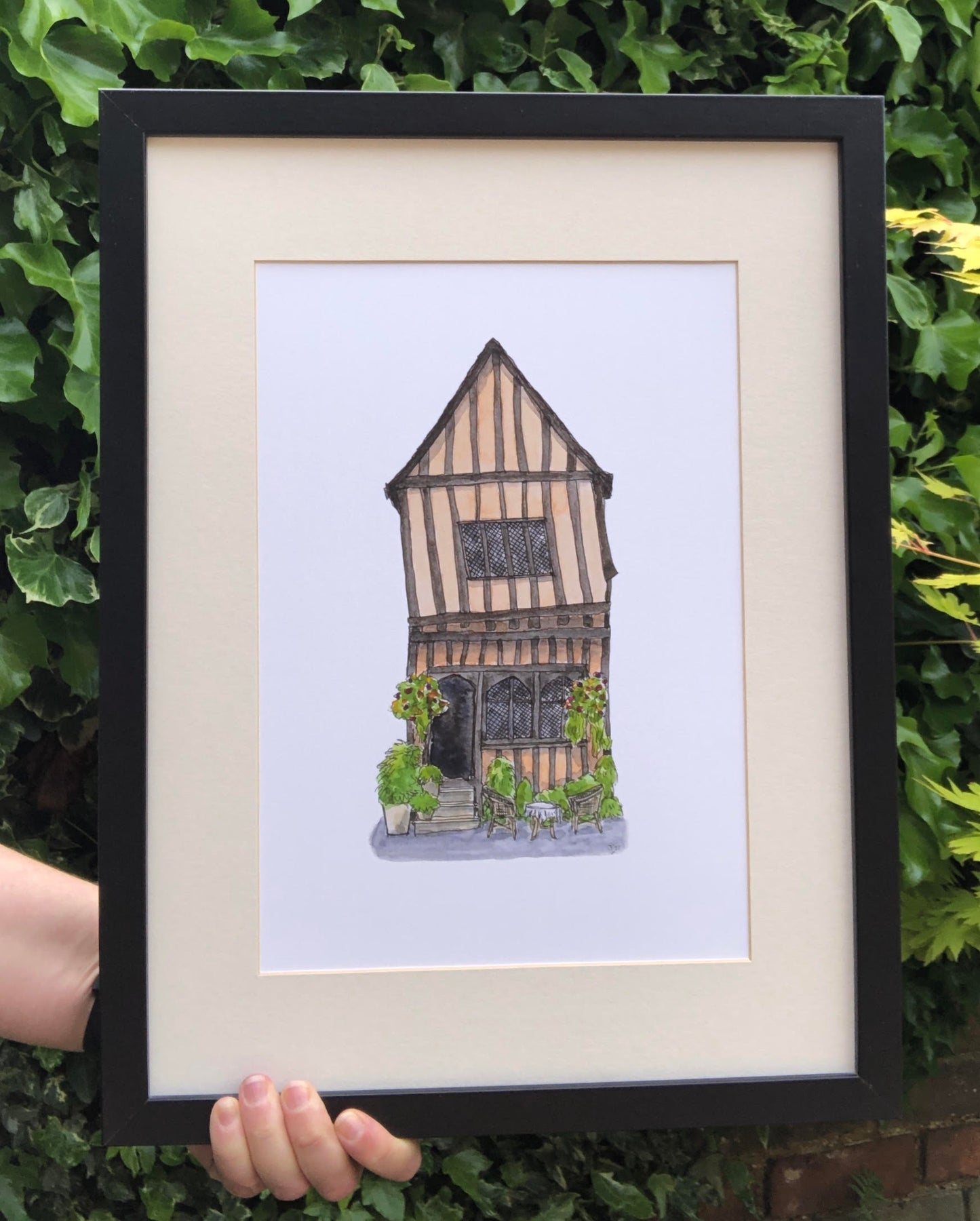 A4 print of Crooked House, Lavenham, presented in a black frame with ivory mount